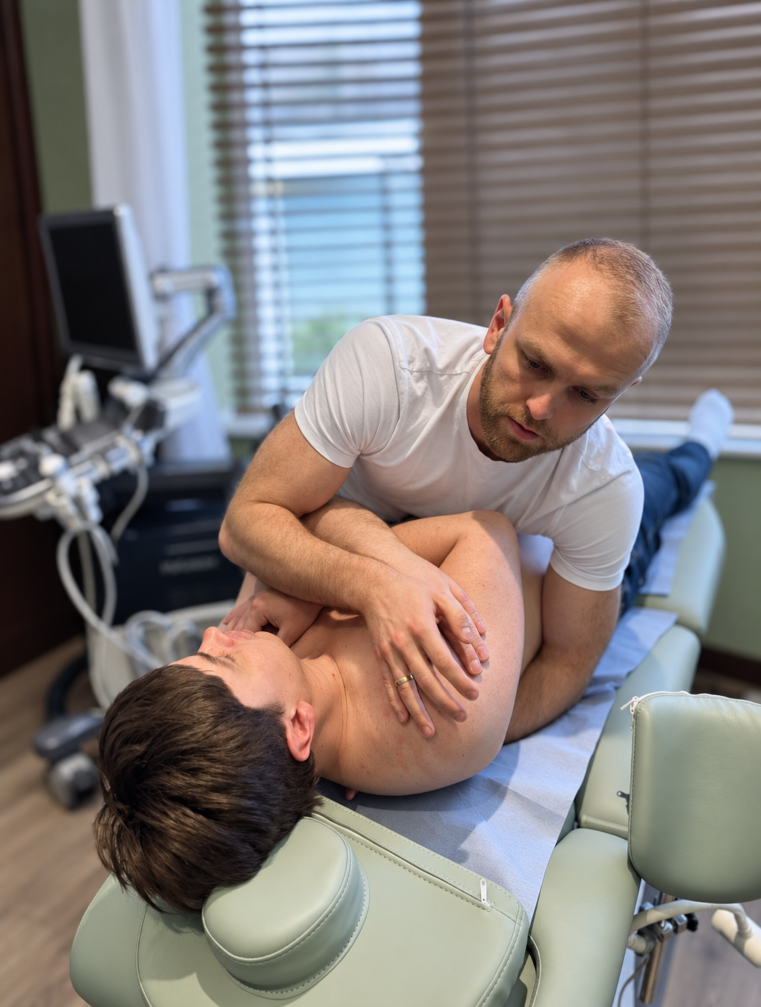 Physiotherapist performing spinal manipulation on a side-lying patient at Phoenix Medical Clinic in Watford.