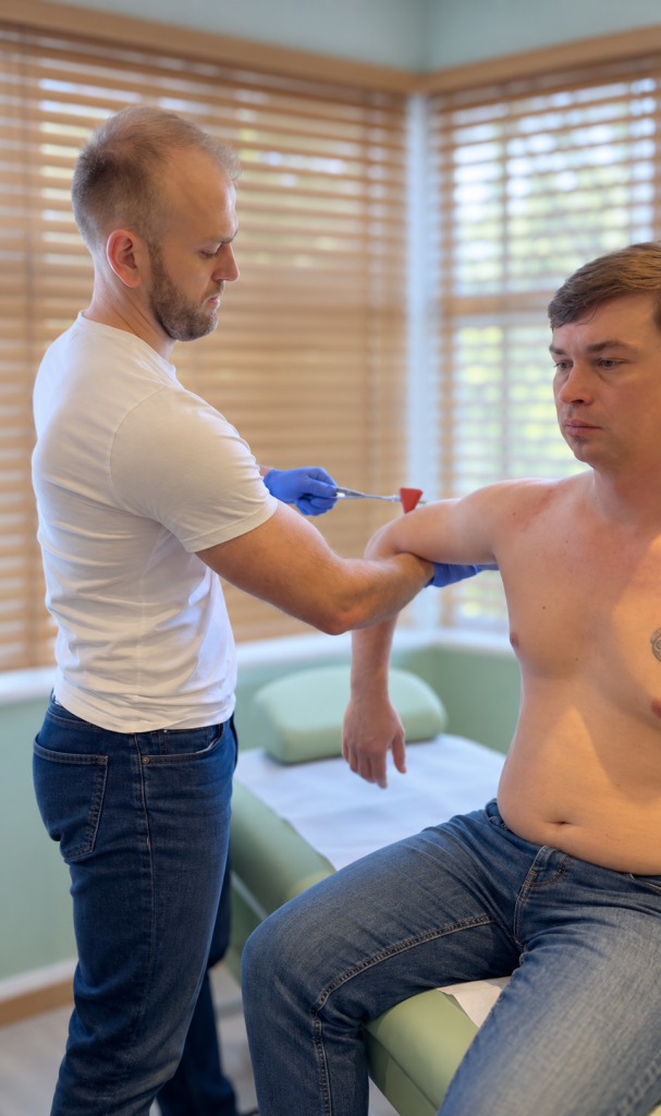 Physiotherapist assessing a patient’s shoulder at Phoenix Medical Clinic in Watford