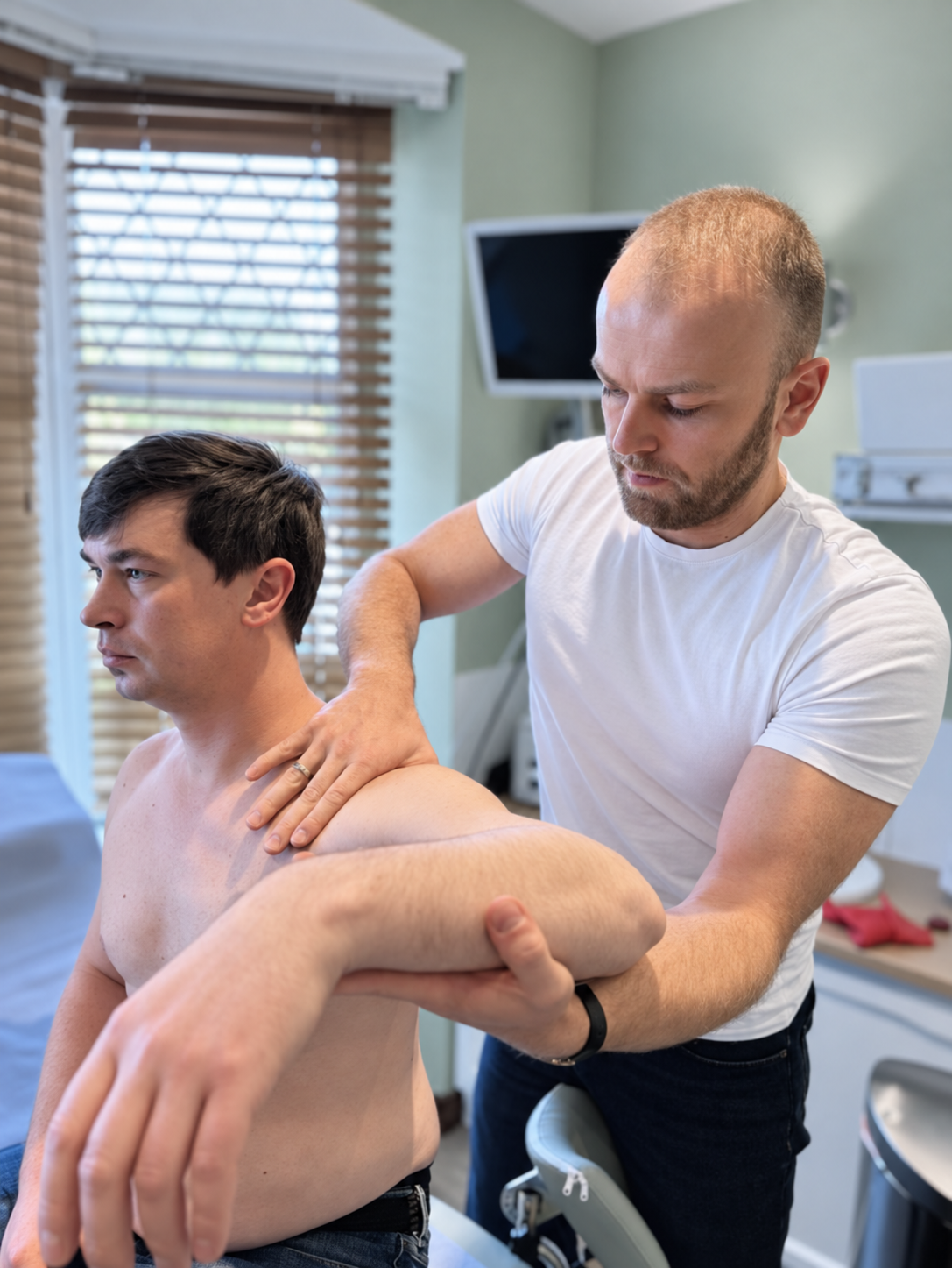 Physiotherapist assessing a patient’s shoulder movement at Phoenix Medical Clinic in Watford.